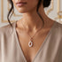 Woman wearing a sterling silver rose gold white ceramic oval link CZ necklace.