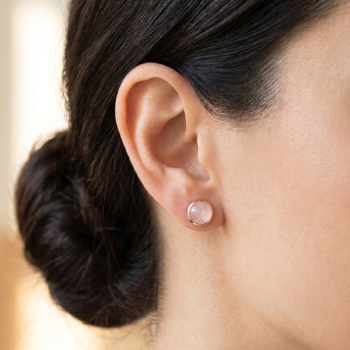 Woman wearing Engelsrufer rose quartz cabochon rose gold stud earrings.