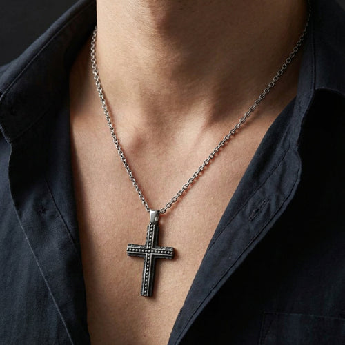 Close up of a man wearing a rough edge black steel cross men's necklace.