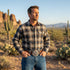 Man standing in a dessert wearing a leather belt with a US Route 66 belt buckle.