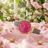 Sara Miller Chelsea Birds 34mm pink dial gold watch on pink fabric in an indoor arboretum.