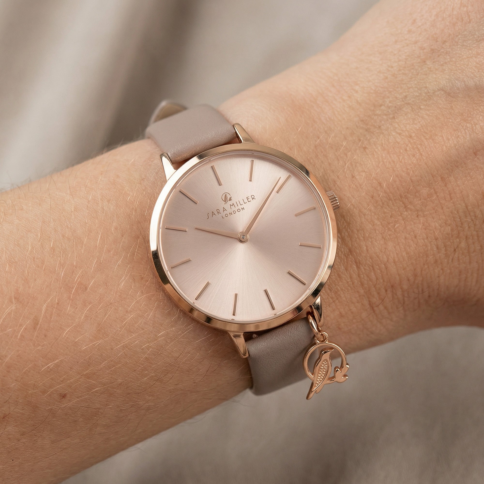 Woman wearing Sara Miller Chelsea Charm 34mm sunray dial rose gold watch.