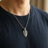 Man in a blue t-shirt wearing a shield cross stainless steel necklace.