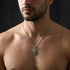 Shirtless man wearing a shield cross stainless steel necklace.