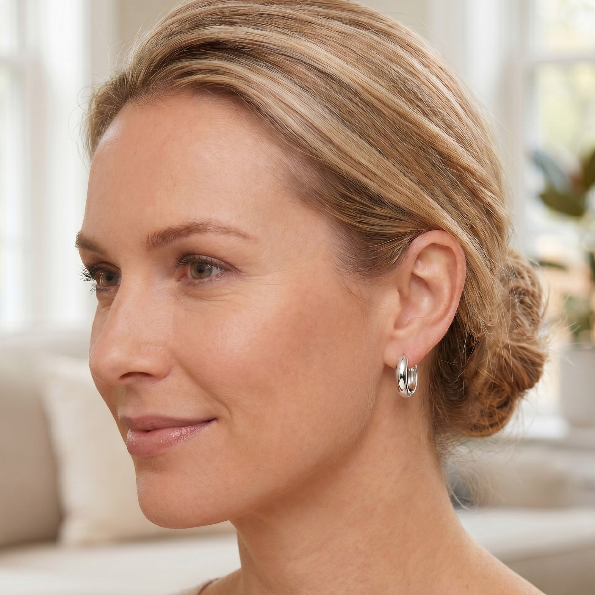 Woman looking to the left and wearing Engelsrufer sterling silver 20mm hoop earrings.