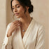 Woman in white blouse wearing an Engelsrufer sterling silver red heart soundball necklace.