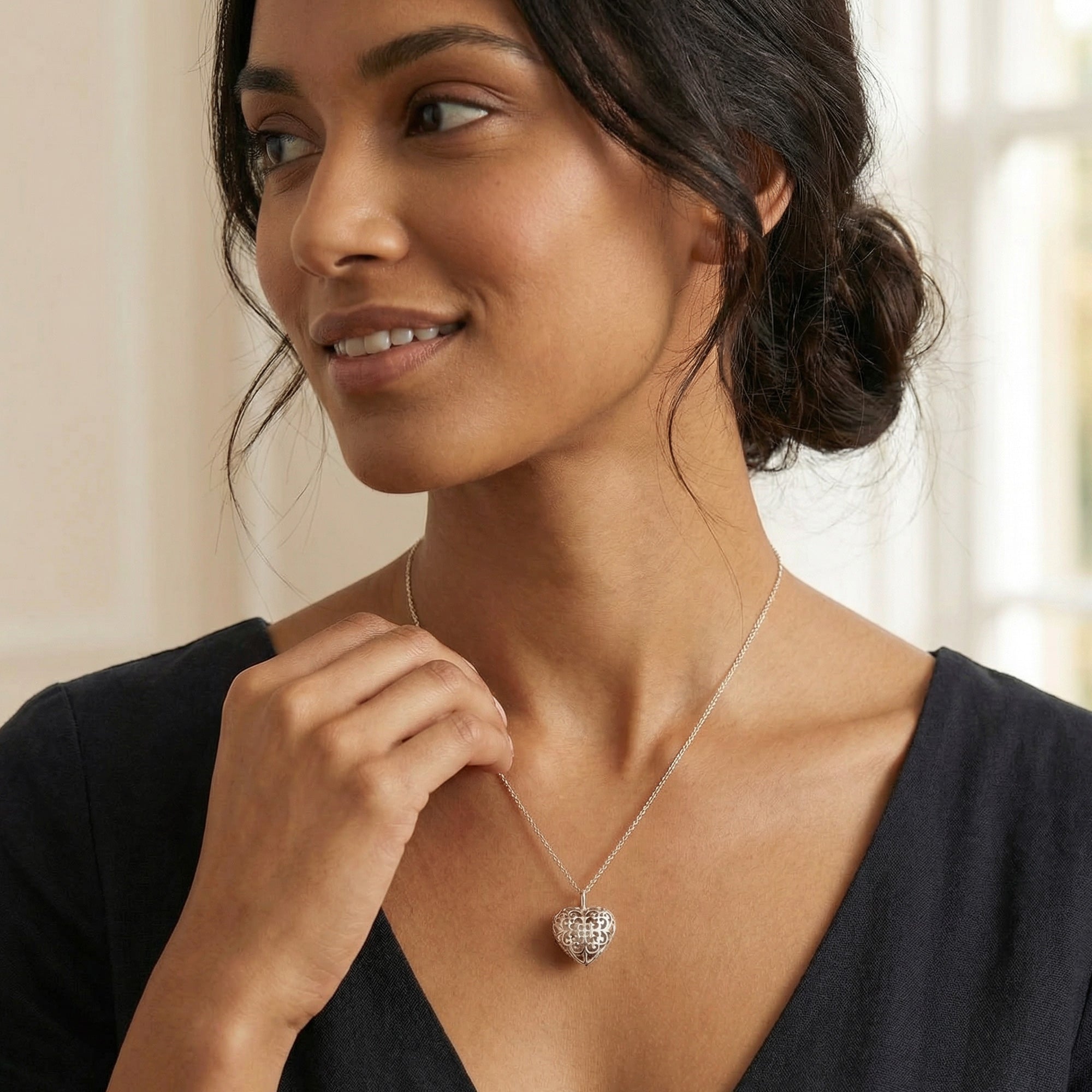 Woman wearing an Engelsrufer sterling silver rose gold heart soundball necklace.