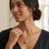 Woman wearing an Engelsrufer sterling silver rose gold heart soundball necklace.