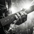 Man playing an electric guitar while wearing memento mori skull cluster stainless steel ring.