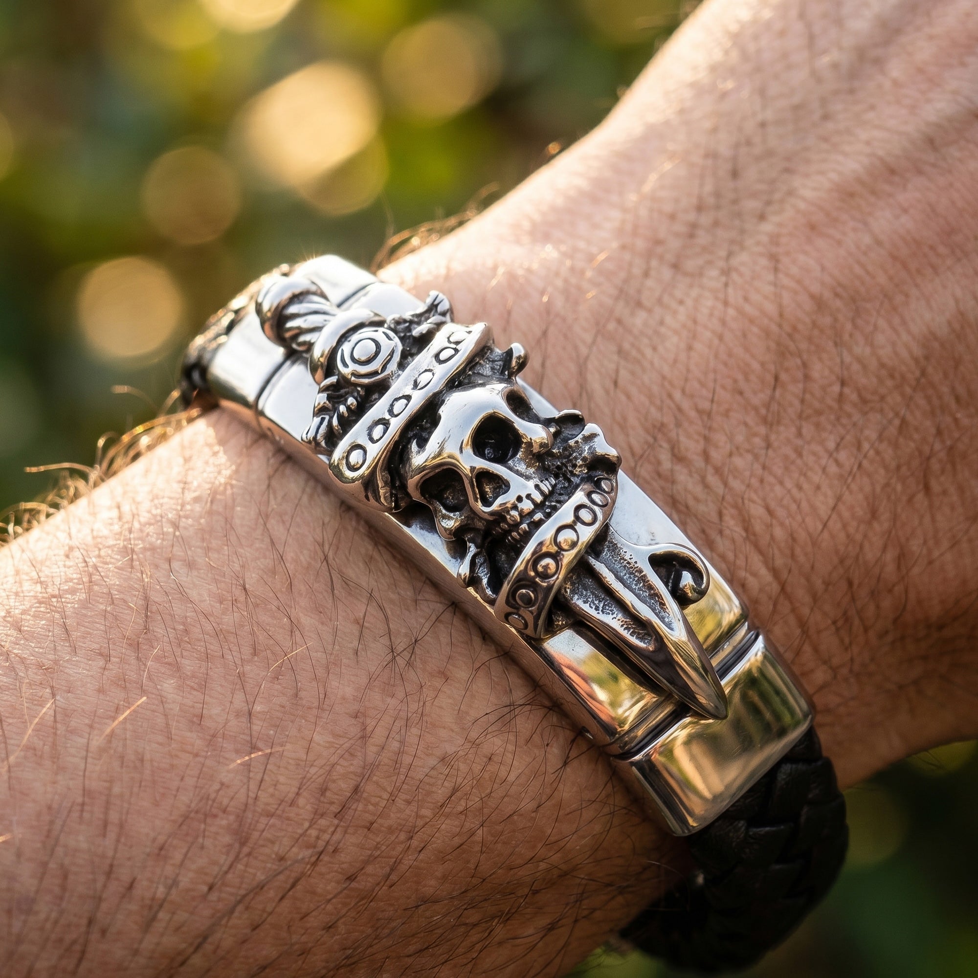 Close-up of man's wrist wearing a Save Brave skull & dagger men's leather bracelet.