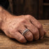 Close-up of a man's hand wearing a stainless steel spine vertebrae ring.