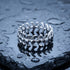 Stainless steel men's spine vertebrae ring laying on a wet piece of black slate.