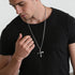 Young man in a black t-shirt wearing barbed cross stainless steel men's necklace.