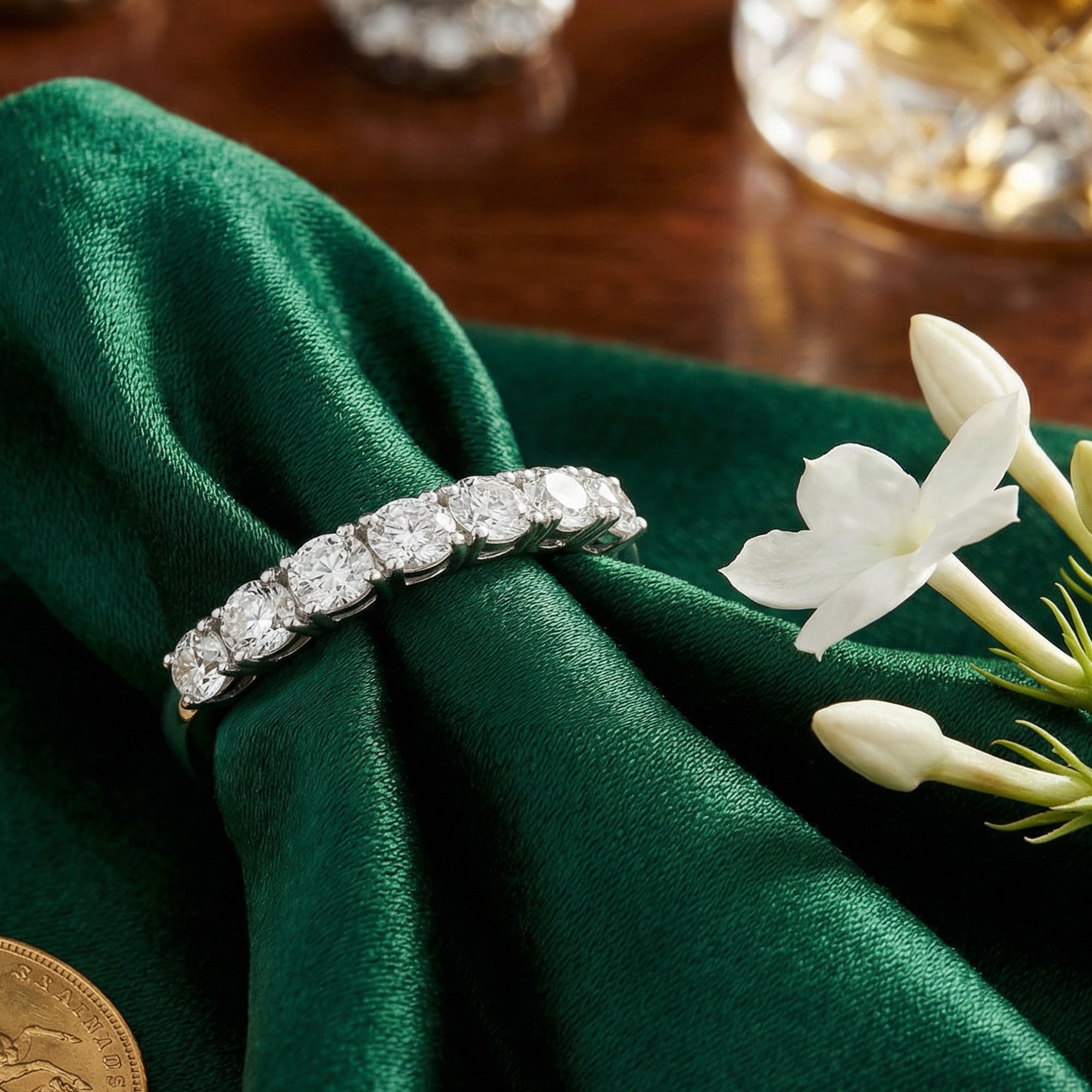Stainless steel seven stone CZ shared prong ring on green fabric with flowers.