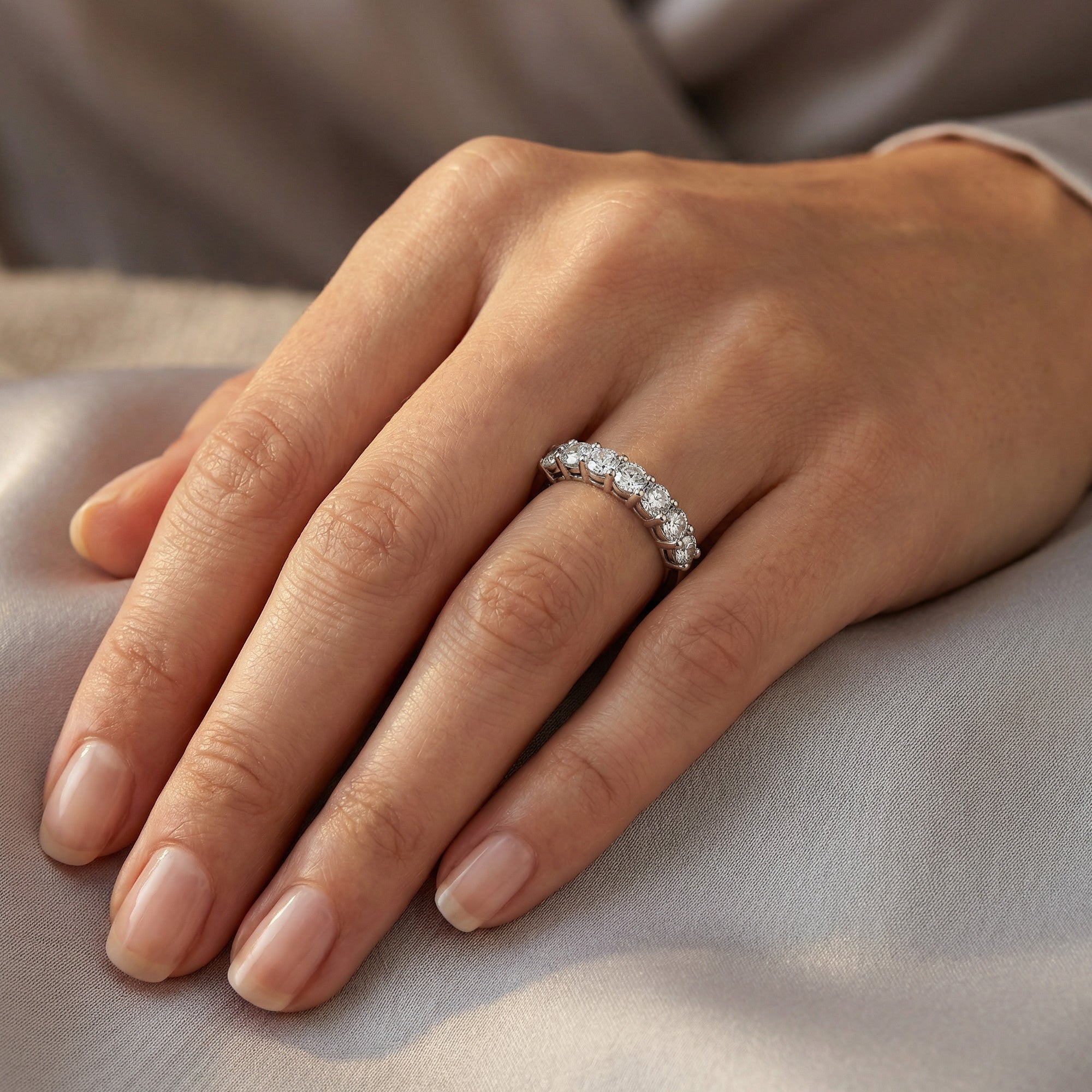 Woman wearing stainless steel seven stone CZ shared prong ring on her hand.
