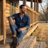Man wearing medical alert stainless steel matt finish dog tag necklace sitting on the steps of a timber cabin verandah.