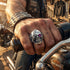 Biker man wearing a stainless steel men's skull eye patch ring on his hand.