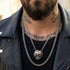 Biker man wearing a stainless steel men's skull eye patch ring on a chain around his neck.