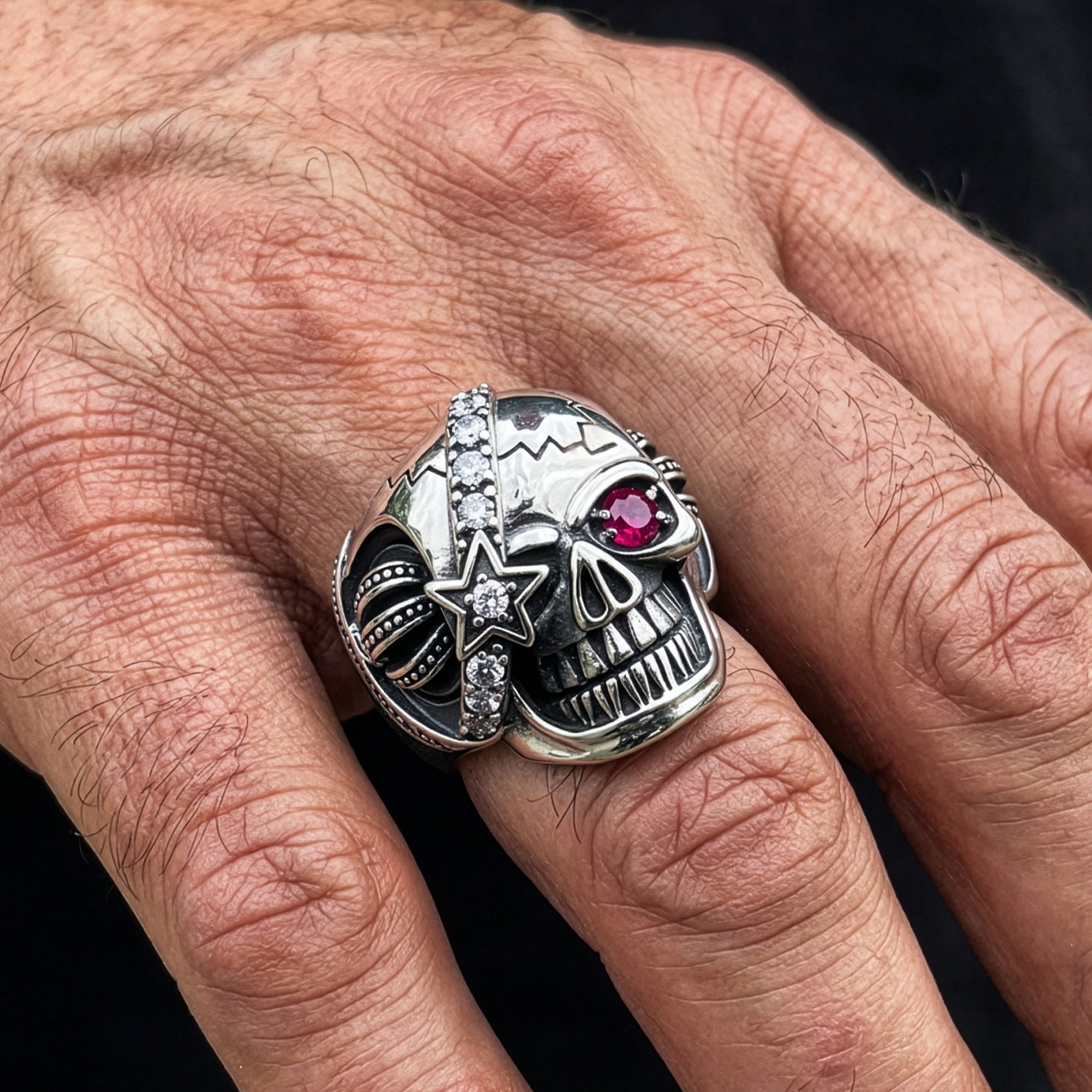Close up man wearing stainless steel men's skull eye patch ring.