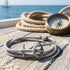 Anchor & Crew Admiral sterling silver grey rope bracelet on jetty with rope and a compass.