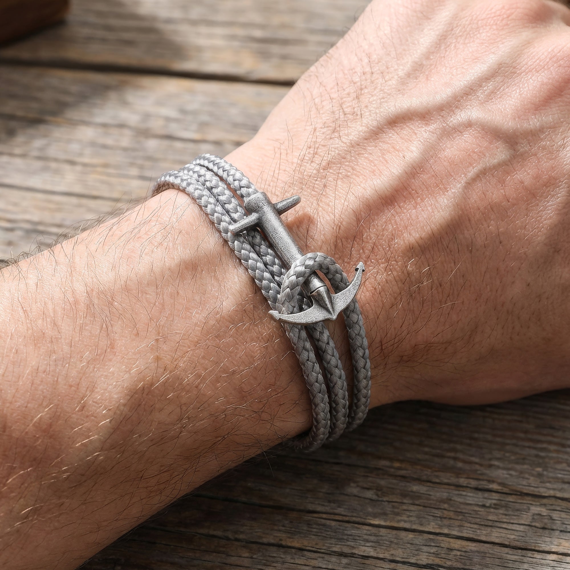 Close-up man's wrist wearing Anchor & Crew Admiral sterling silver grey rope bracelet.