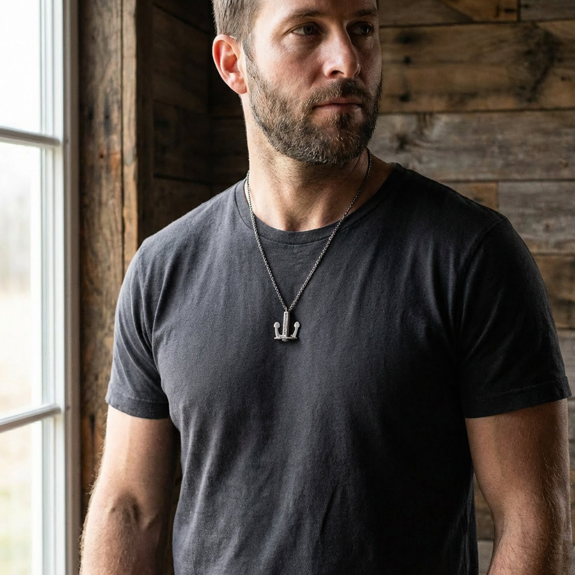 Man standing by a window wearing an Anchor & Crew Union anchor sterling silver necklace.