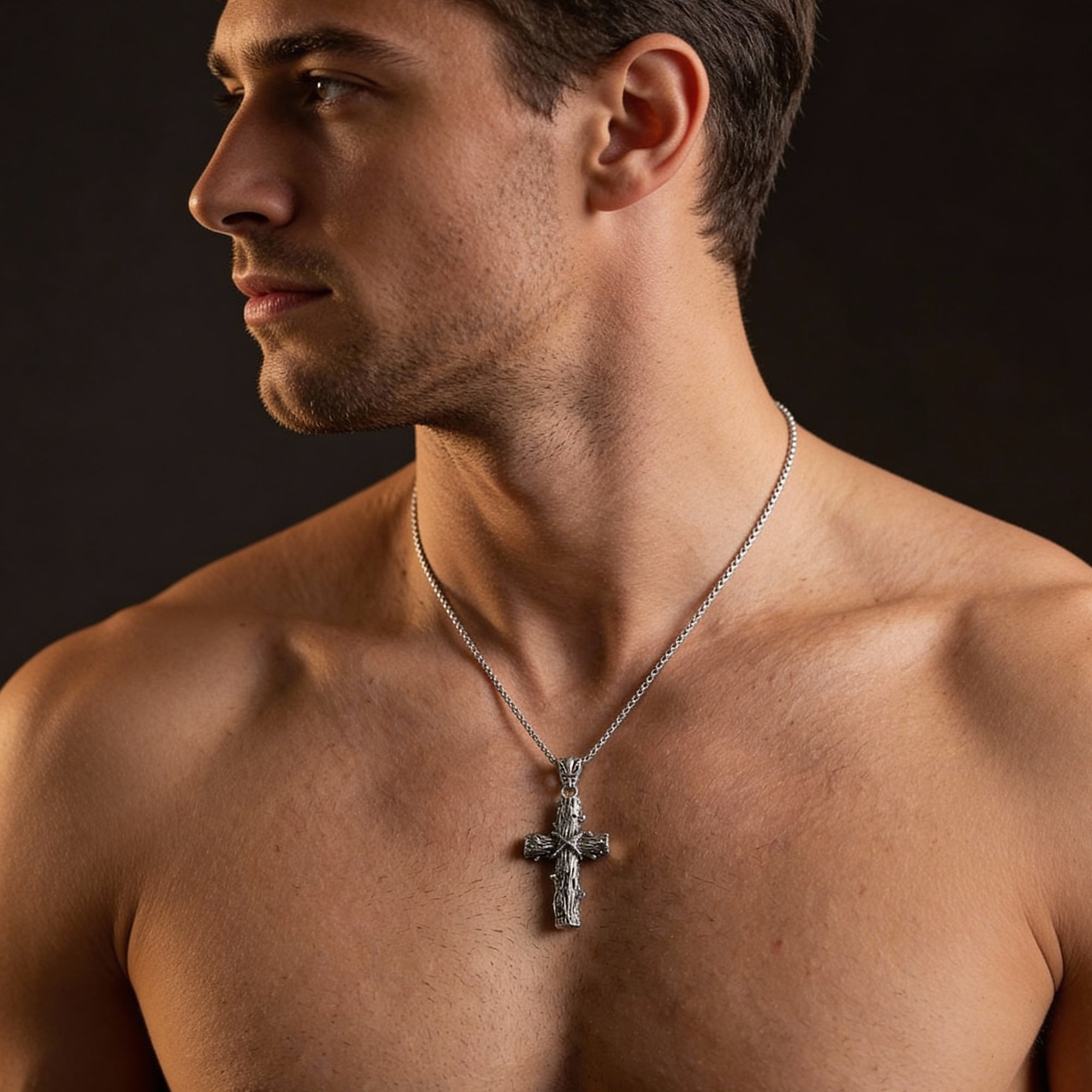 Front view of a man wearing a sterling silver lashed wood cross necklace.