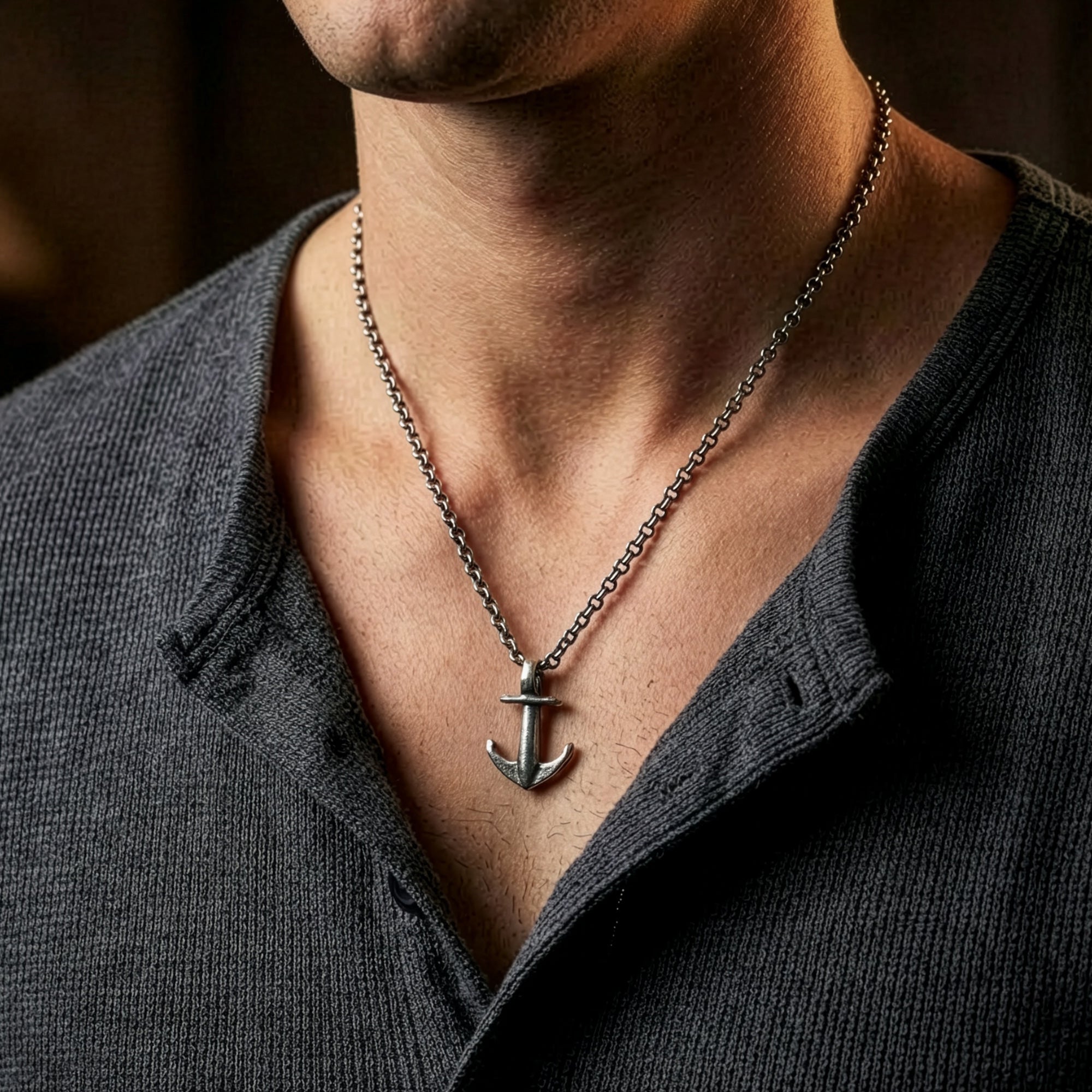 Man in an open-neck shirt wearing Anchor & Crew mini anchor sterling silver necklace.
