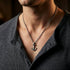 Man in an open-neck shirt wearing Anchor & Crew mini anchor sterling silver necklace.
