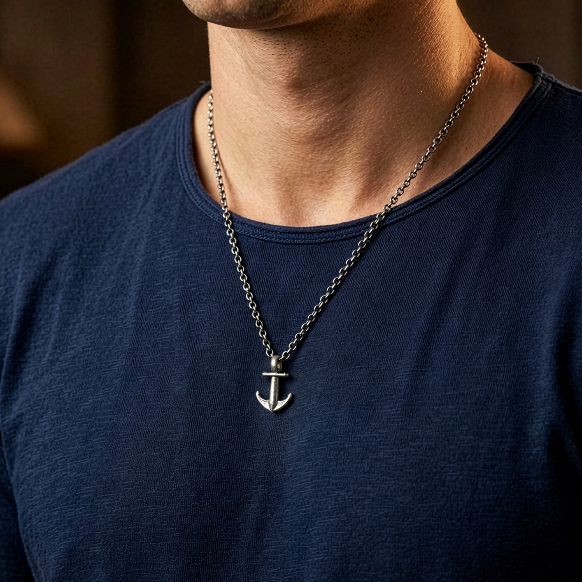 Man in a blue t-shirt wearing Anchor & Crew mini anchor sterling silver necklace.