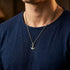 Man in a blue t-shirt wearing Anchor & Crew mini anchor sterling silver necklace.