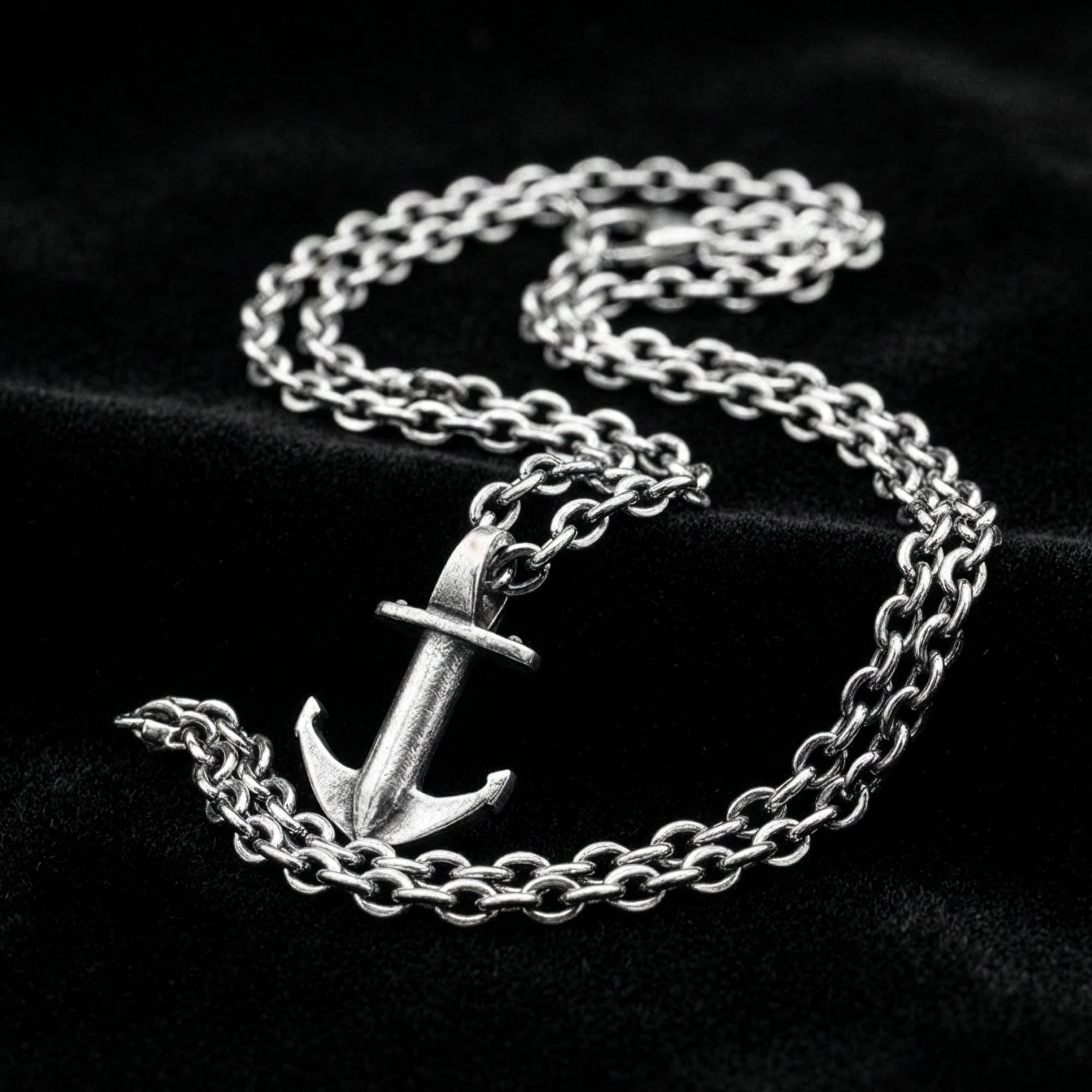 Anchor & Crew mini anchor sterling silver necklace on black velvet fabric.