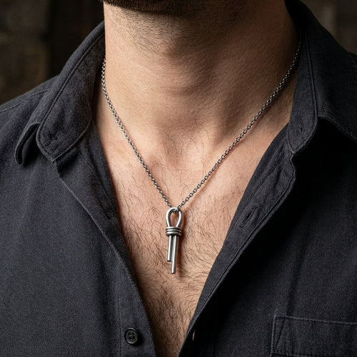 Close-up of a man in an open-neck shirt wearing a sterling silver nautical scaffold knot men's necklace.