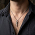 Close-up of a man in an open-neck shirt wearing a sterling silver nautical scaffold knot men's necklace.