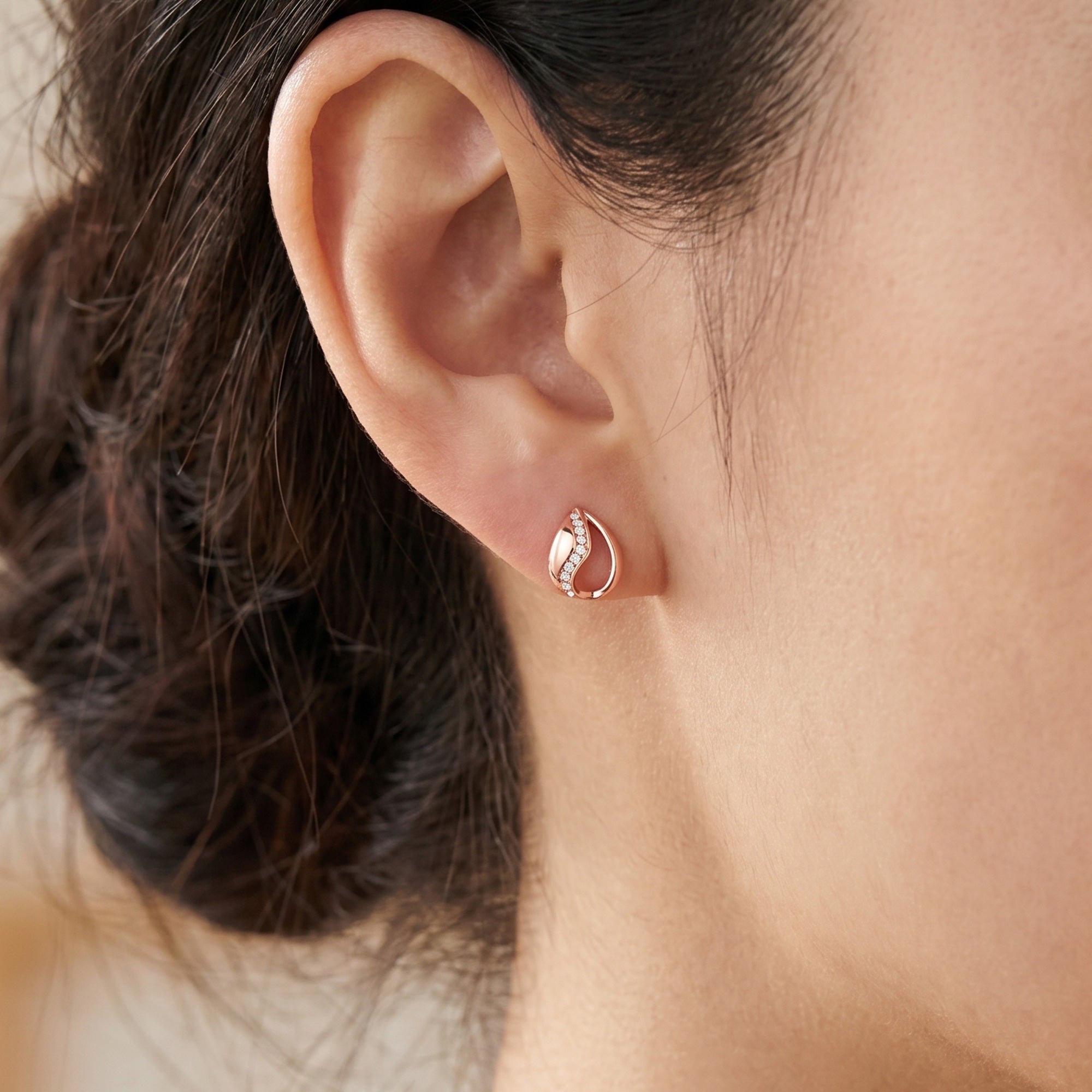 Woman wearing Engelsrufer Tear Of Heaven rose gold CZ earrings.