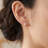 Woman wearing Engelsrufer Tear Of Heaven rose gold CZ earrings.