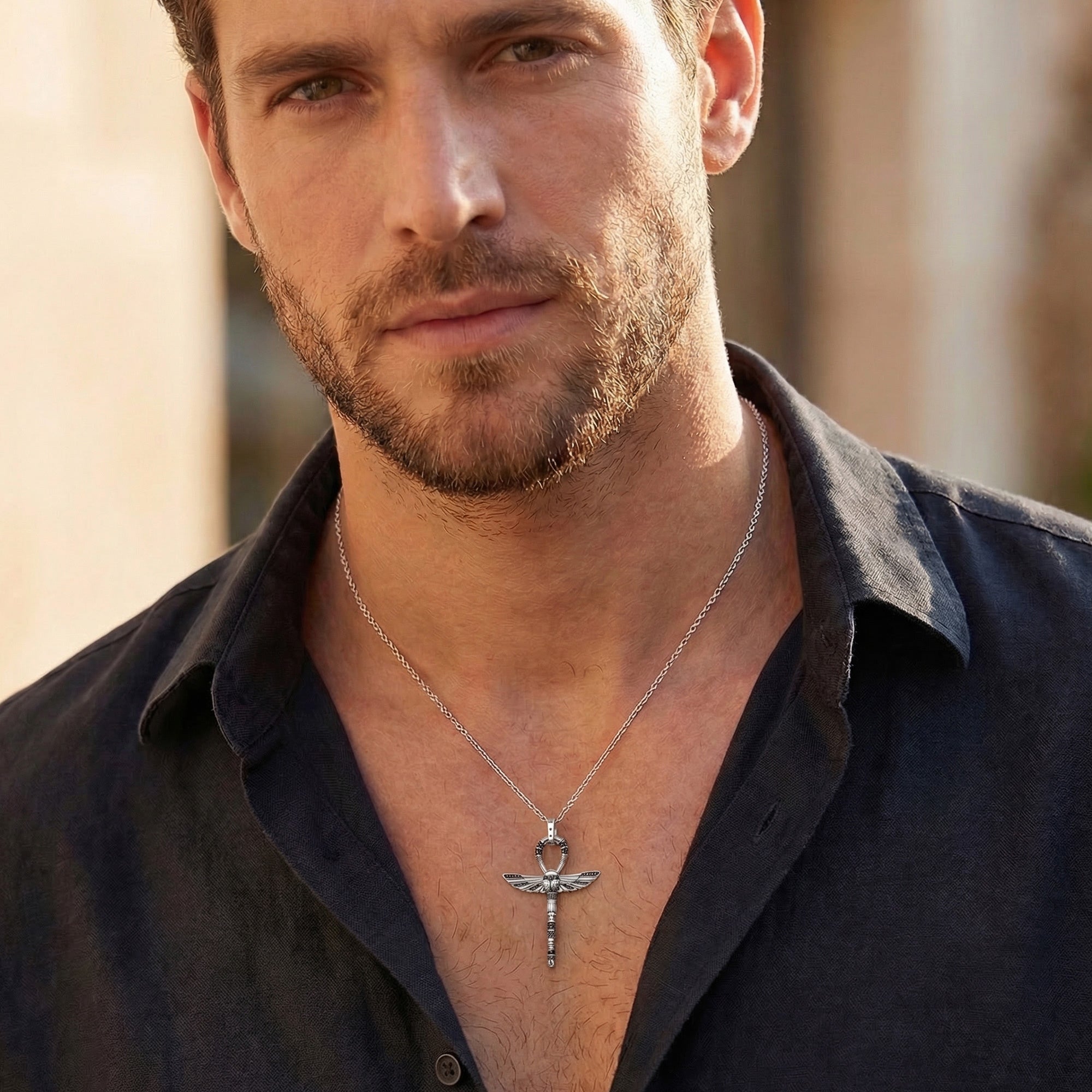 Man in open-neck shirt wearing Thomas Sabo cross of life ankh scarab pendant.