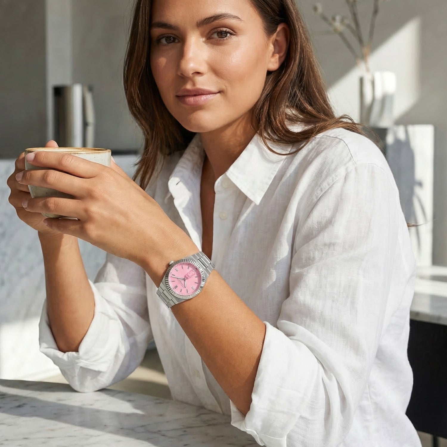 Woman holding a coffee cup while wearing a Thomas Sabo Haribo Goldbear pink dial silver watch on her wrist.