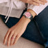 Woman in blue jeans wearing a Thomas Sabo Haribo Goldbear pink dial silver watch on her wrist.