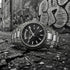 Thomas Sabo Rebel At Heart Revive 36mm black dial watch laying on the cracked asphalt of an empty urban alleyway with graffiti in the background.