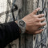 Man wearing a Thomas Sabo Rebel At Heart Revive 36mm black dial watch resin this hand on a concrete wall with graffiti. 