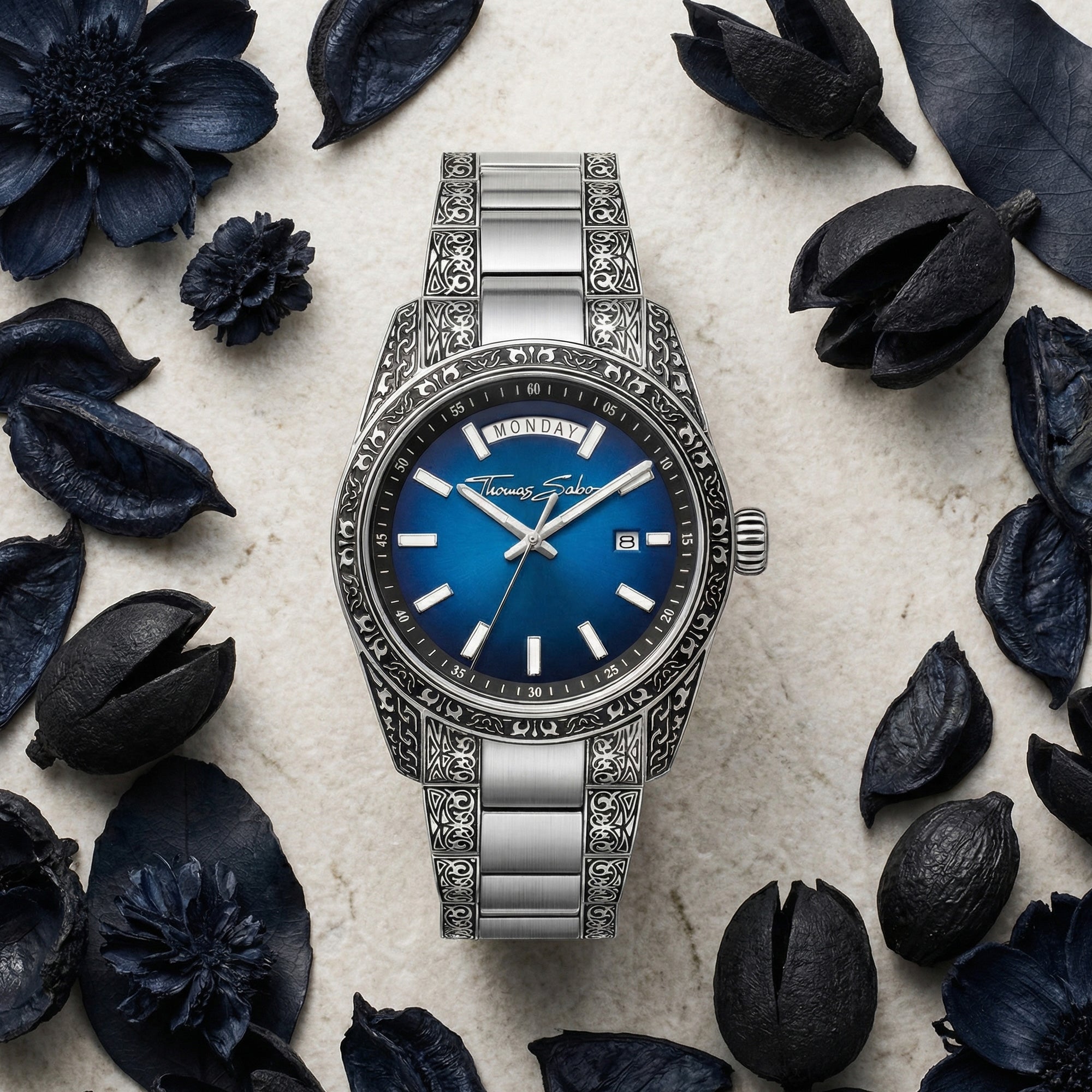 Thomas Sabo Rebel At Heart Revive 40mm blue dial watch surrounded by dried obsidian blue botanical matter.