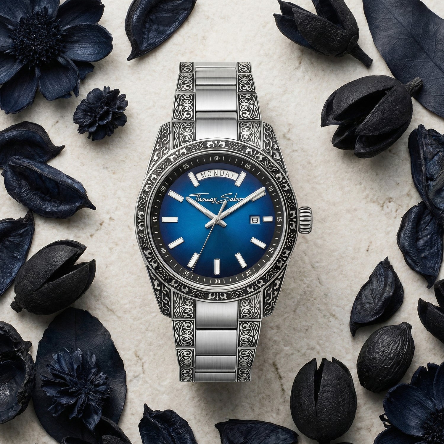 Thomas Sabo Rebel At Heart Revive 40mm blue dial watch surrounded by dried obsidian blue botanical matter.
