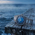 Thomas Sabo Rebel At Heart Revive 40mm blue dial watch on the edge of an old wooden pier with the sea frothing in the background.