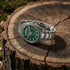 Thomas Sabo Rebel At Heart Revive 36mm green dial watch resting on the cross-section of a tree trunk.