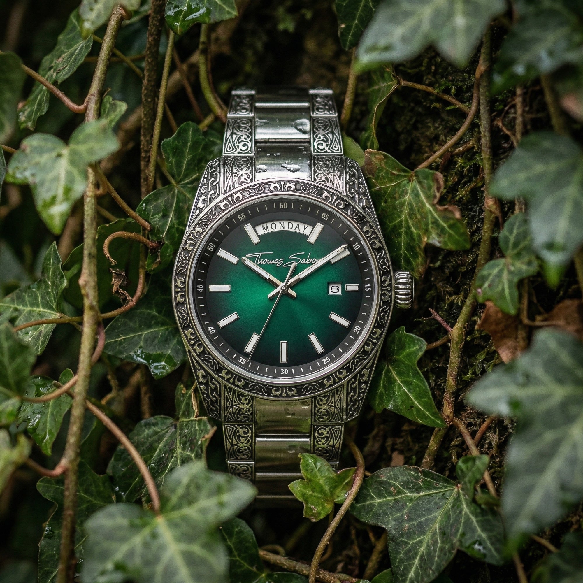 Thomas Sabo Rebel At Heart Revive 40mm green dial watch laying in a clump of dark green ivy.