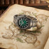 Thomas Sabo Rebel At Heart Revive 40mm green dial watch laying on the page of an old manuscript depicting botanical illustrations of acanthus.