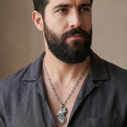 Man wearing a Thomas Sabo Rebel Wolf sterling silver pendant on a wide chain.