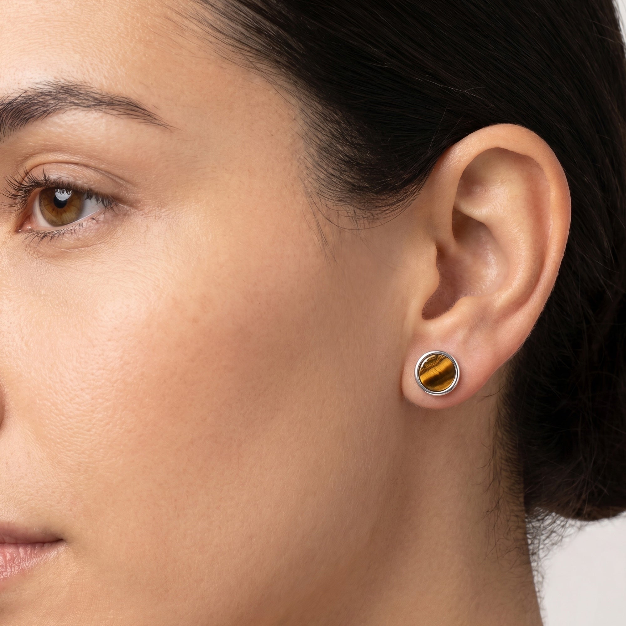 Woman wearing Engelsrufer tiger eye sterling silver circle earrings.