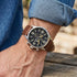 Man wearing Timberland Rutherford black dial brown leather watch.